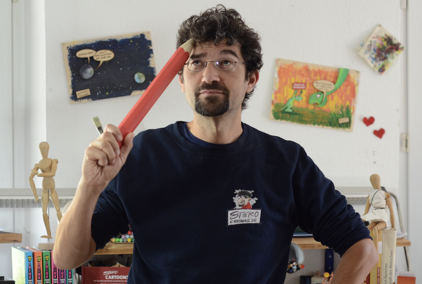 STERO Stefan Roth Cartoonzeichner mit rotem riesenbleistift - kratzt sich am Kopf