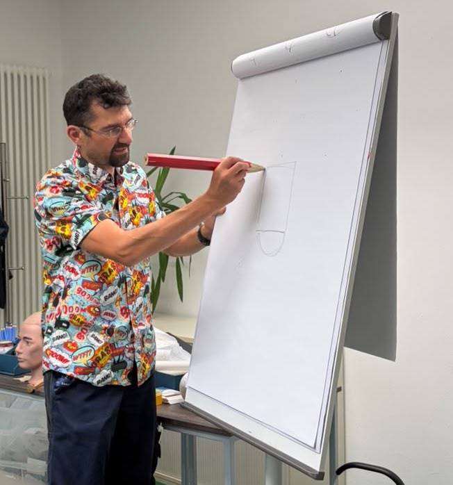 STERO CARTOONS erklärt an einem Flipchart eine Zeichnung während eines Zeichenworkshops.
